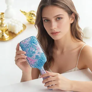 Woman holding a sparkly square paddle hairbrush with purple and blue butterfly patterns
