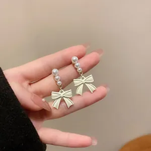 Macro detail showing the elegant pearl arrangement and bow-knot drop earrings for women