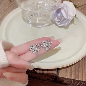 Close-up of elegant S925 silver heart-shaped stud earrings with sparkling zirconia.