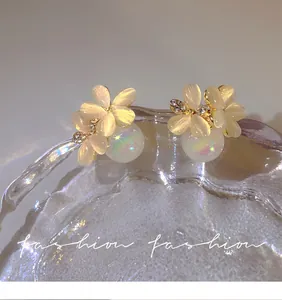 Close-up of elegant floral stud earrings with iridescent pearls and fine crystals