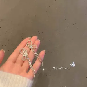 Detailed close-up of S925 silver bow earrings with sparkling rhinestone tassels