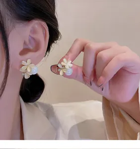 Close-up view of elegant flower earrings with pearls and 925 silver needle details.