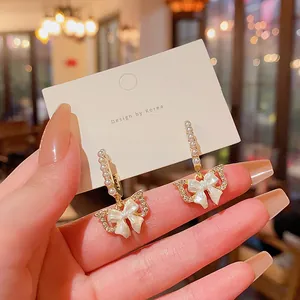 Close-up of elegant butterfly bow earrings with pearls and crystal accents