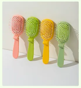 Detail shot of four colorful folding airbag massage hairbrushes in pink, yellow, and green.