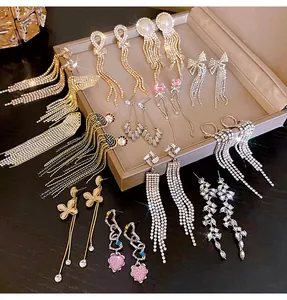 Elegant long tassel earrings collection with sparkling crystals in a display tray.