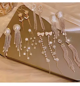 Elegant long tassel earrings with pearls and sparkling rhinestones on silk backdrop