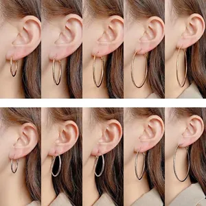 Comparison of 3cm to 7cm gold and silver hoop earrings on model's ear for size guide