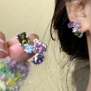 Close-up detail showing multi-colored zircon stud earrings with a 925 silver needle