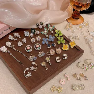 Elegant collection of S925 silver floral and butterfly earrings on a wooden display.