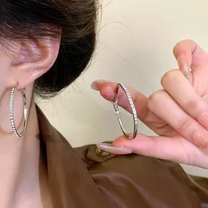 Close-up of sparkling silver hoop earrings with delicate crystal accents.