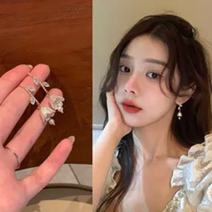 Detailed view of lily of the valley drop earrings with crystal accents on a model