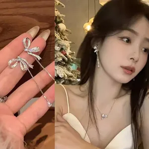 Close-up of elegant zircon bow tassel earrings and matching necklace set