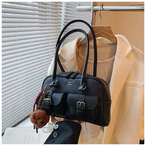 Detalle del bolso vintage negro bajo el brazo con múltiples bolsillos