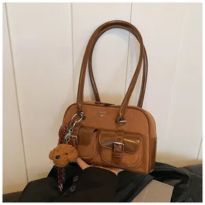 Detalle de bolso de hombro vintage de gamuza marrón con múltiples bolsillos