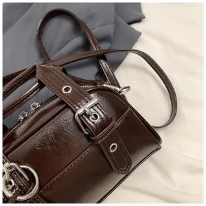 Macro view of retro brown faux leather bag with buckle and silver hardware detail