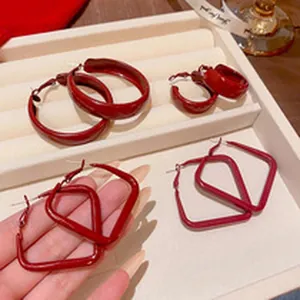 Primer plano de pendientes magnéticos rojos redondos y cuadrados en una bandeja de joyas