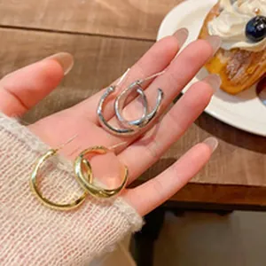 Detailed macro shot of twisted metal hoop earrings in elegant silver and gold finishes