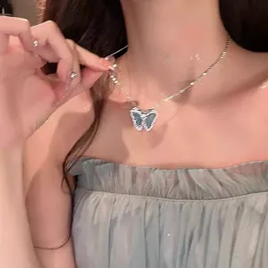 Elegant butterfly pendant necklace with sparkling stone-encrusted border on model