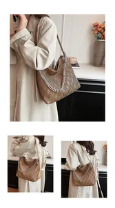 Detailed view of the brown pleated tote bag with silver chain and shoulder strap