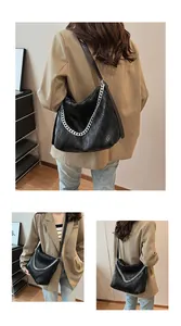Multiple views of black textured tote bag with silver chain on model in tan blazer