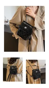 Vue détaillée du sac à dos en cuir matelassé noir avec bretelles en chaîne et fermoir pivotant
