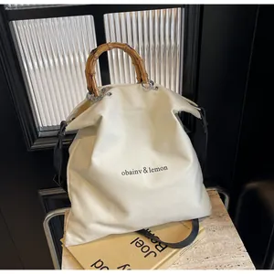 Large capacity cream canvas tote bag with natural bamboo handles and minimalist logo