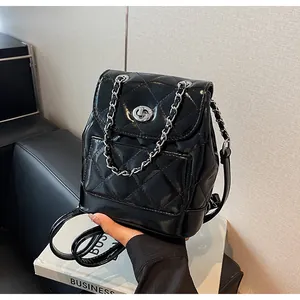 Gros plan détaillé d'un sac à dos en cuir matelassé noir brillant avec chaîne argent