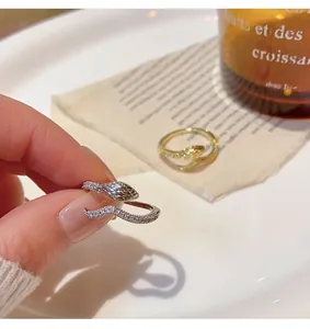 Detailed close-up of a silver twisted snake-shaped open ring with micro pavé settings.