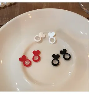 Macro view of heart-shaped silicone earring backs in white, red, and black colors.