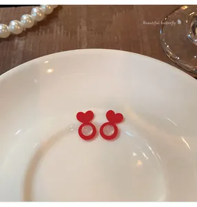 Detailed macro view of red heart-shaped silicone earring lifters on a white plate