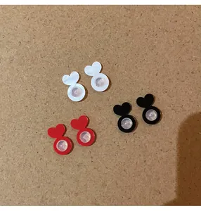 Detail view of heart-shaped silicone earring back supports in white, red, and black