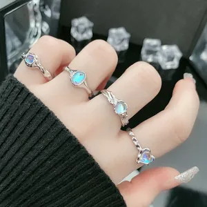 Gedetailleerde weergave van vier minimalistische zilveren ringen met blauwe maanstenen