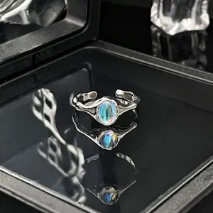 Detailopname van een zilveren open ring met maansteen en een elegante blauwe glans.
