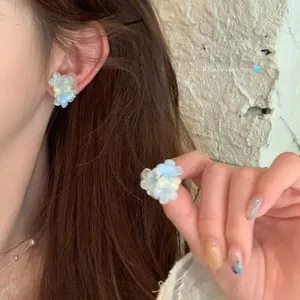 Detail shot of clear blue beaded flower earrings with a delicate gradient effect