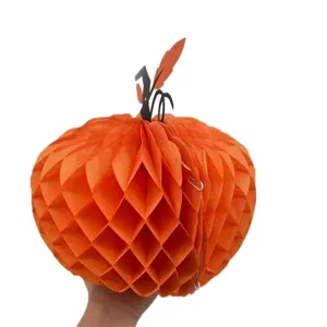 Detailweergave van een feloranje papieren honingraatpompoen voor Halloween-feestversieringen