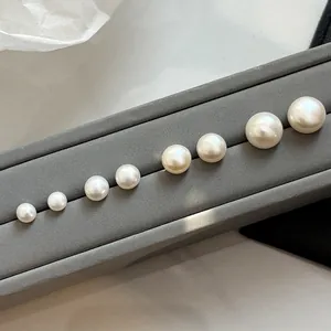 Natural freshwater white bun pearl stud earrings in various sizes on a display stand