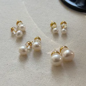 Assorted sizes of natural freshwater pearl stud earrings on textured fabric background