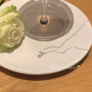 Elegant close-up of a silver teardrop pendant necklace on a plate with a white rose
