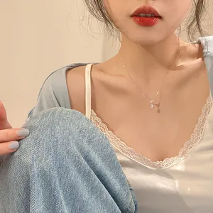 Detail shot of a titanium steel mermaid tear necklace on an elegant Asian model.