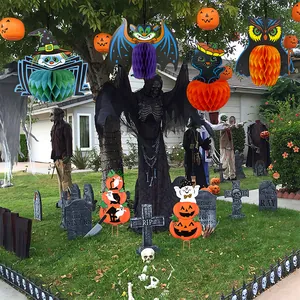 Scène d'Halloween en plein air avec décorations suspendues en papier alvéolé coloré