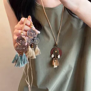 Bohemian style necklace featuring coffee tassels and shell accents on a long cord