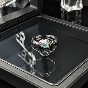 Gedetailleerd overzicht van een minimalistische zilveren open ring met maansteen inleg.