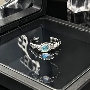 Close-up van een minimalistische zilverkleurige open ring met een ovale maansteen.