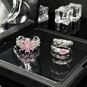 Nahaufnahme von eleganten Silberringen mit Blumen- und Spiraldesign mit rosa Edelsteinen