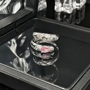 Detail eines silbernen Rings mit pinkfarbenem Stein und funkelnden Stern-Kristallen.