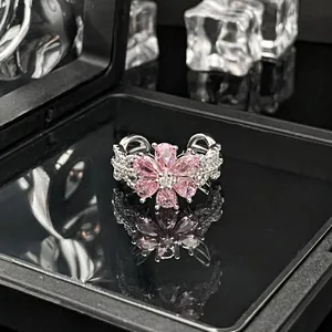 Detailansicht eines silbernen Rings mit einer rosa Kristallblume und Pavé-Band