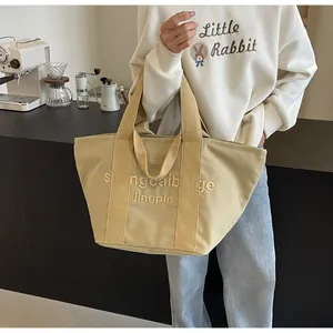 Nahaufnahme einer großen Canvas-Einkaufstasche mit gestickten Buchstaben