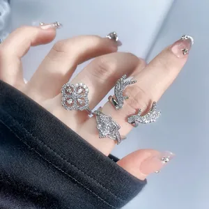Close-up detail of silver-toned antler and clover rings with sparkling stones on hand