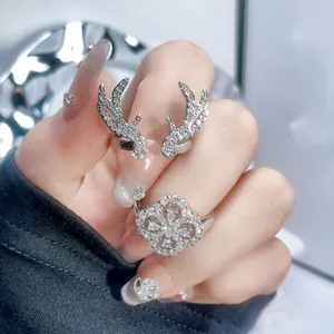 Detailed macro shot of silver antler and four-leaf clover rings with sparkling rhinestones
