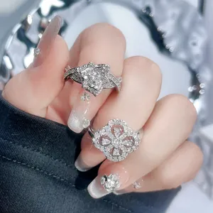 Detailed close-up of silver rings with sparkling flower and four-leaf clover designs.